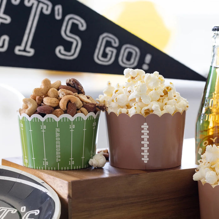 A football party showing the football cups filled with snacks.